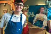 Brandon Rosas ’20 with one of the paintings he produced over the summer.