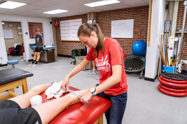 Ashley Meldrum ’20 works on a student-athlete in Central’s athletic training room.