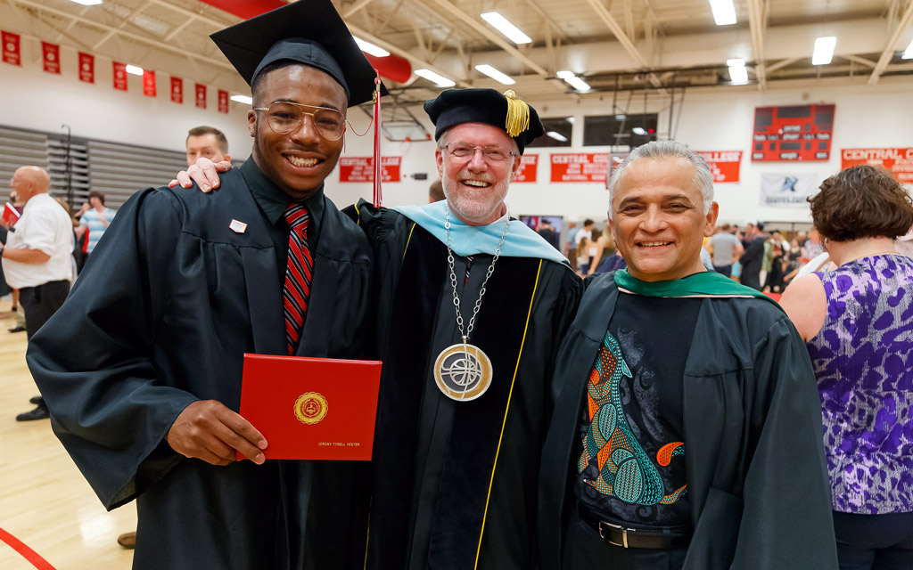 President Mark Putnam, center, and Associate Professor of Music Gabriel Espinosa ’79 congratulate Jeremy Vester ’19 following graduation.