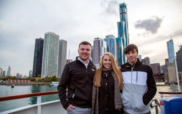 Pictured from left to right, Zach Goering ’22, Sam DePauw ’22 and Alex Garcia ’22 pose in front of Vista Tower during a frigid boat tour along the Chicago River in late October.