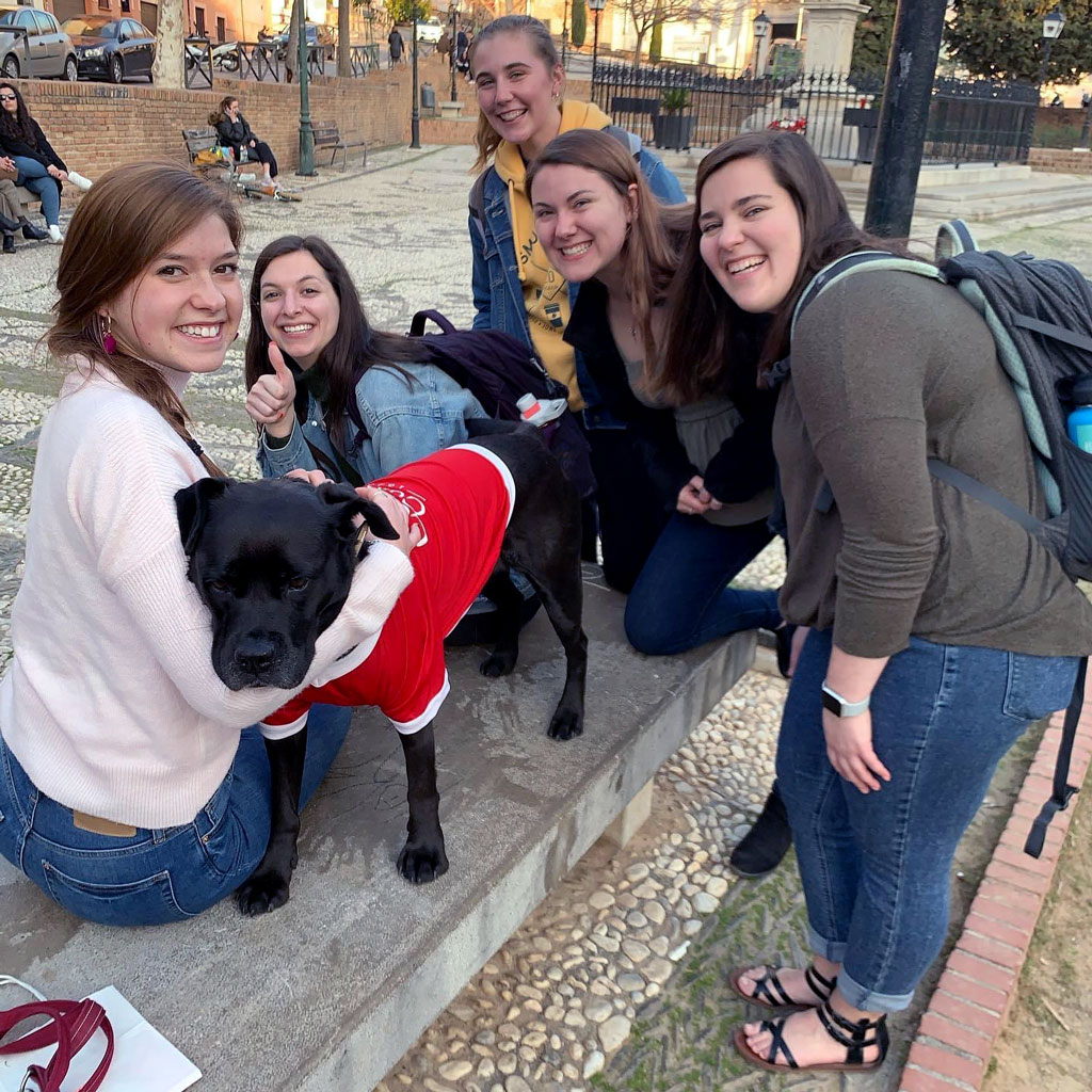 Laurynn Mize ’21 and other students posing for a photo with a dog