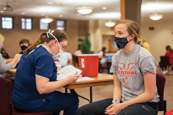 A student receives her COVID-19 vaccination on campus.