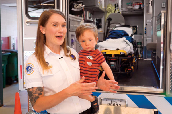 City of Wes Des Moines paramedic, Lisa Schwalenberg Johnson ’07, holding her son Riker, began her career in public service while a student at Central College.