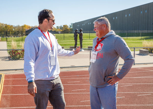 Former Dutch defensive lineman Garrett Hill ’09 chats with his former Central defensive coordinator Don De Waard ’82 as part of the football squad’s Legacy Day activities Nov. 6.