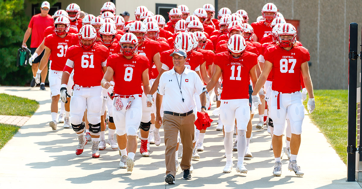 Coach McMartin entering Schipper Stadium with football team